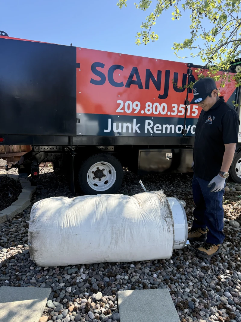 Crew member loading items next to ScanJunk branded truck