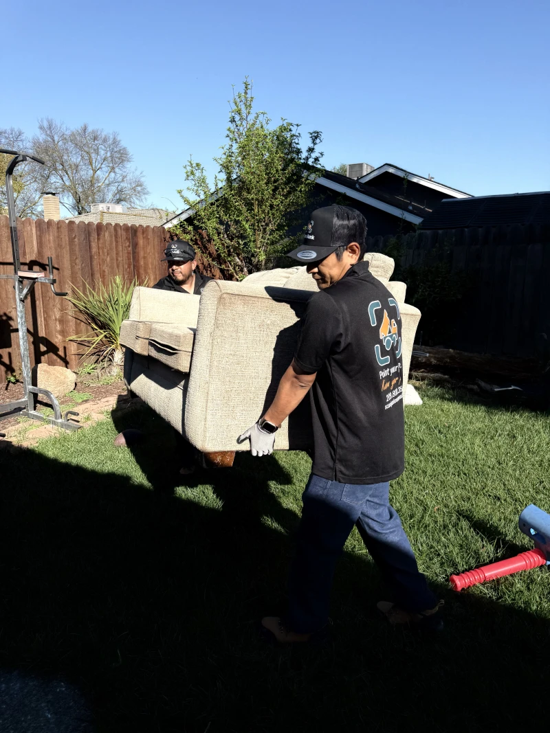 ScanJunk crew member loading sofa onto removal truck