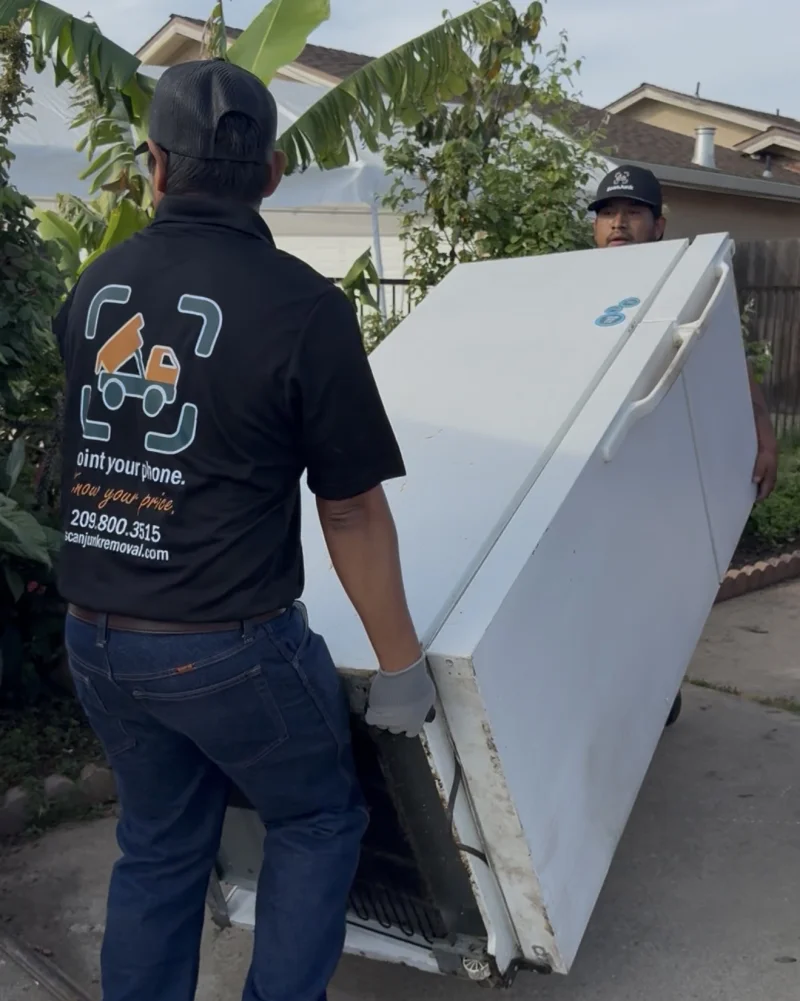 ScanJunk crew removing old refrigerator during junk removal job in Stockton